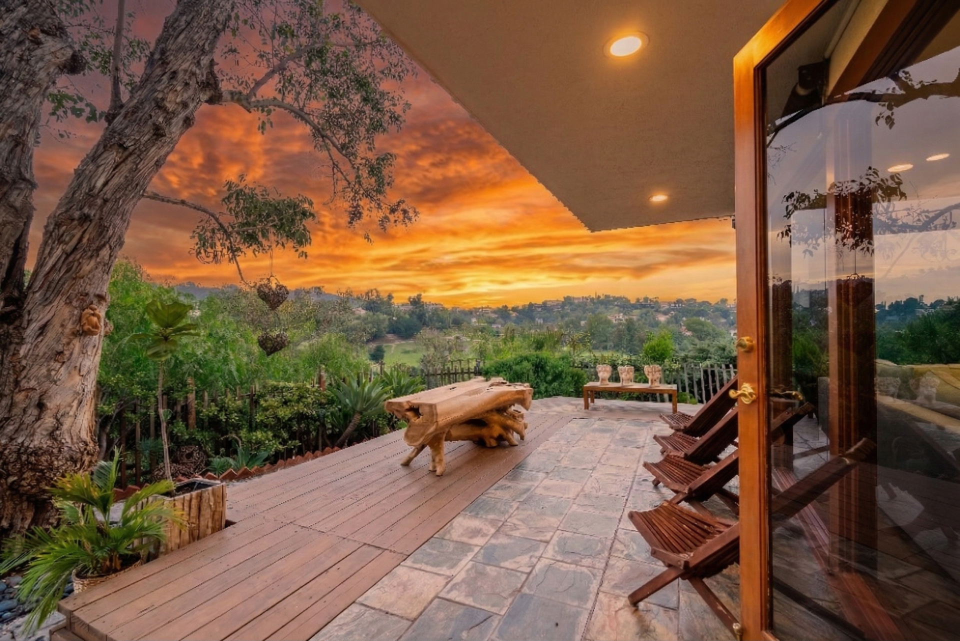 The sanctuary's wooden deck at sunset, looking out over the Woodland Hills with a fiery orange sky